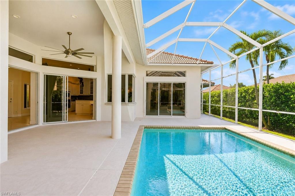 Screened lanai with a rectangular swimming pool, spacious deck, and multiple sliding glass doors