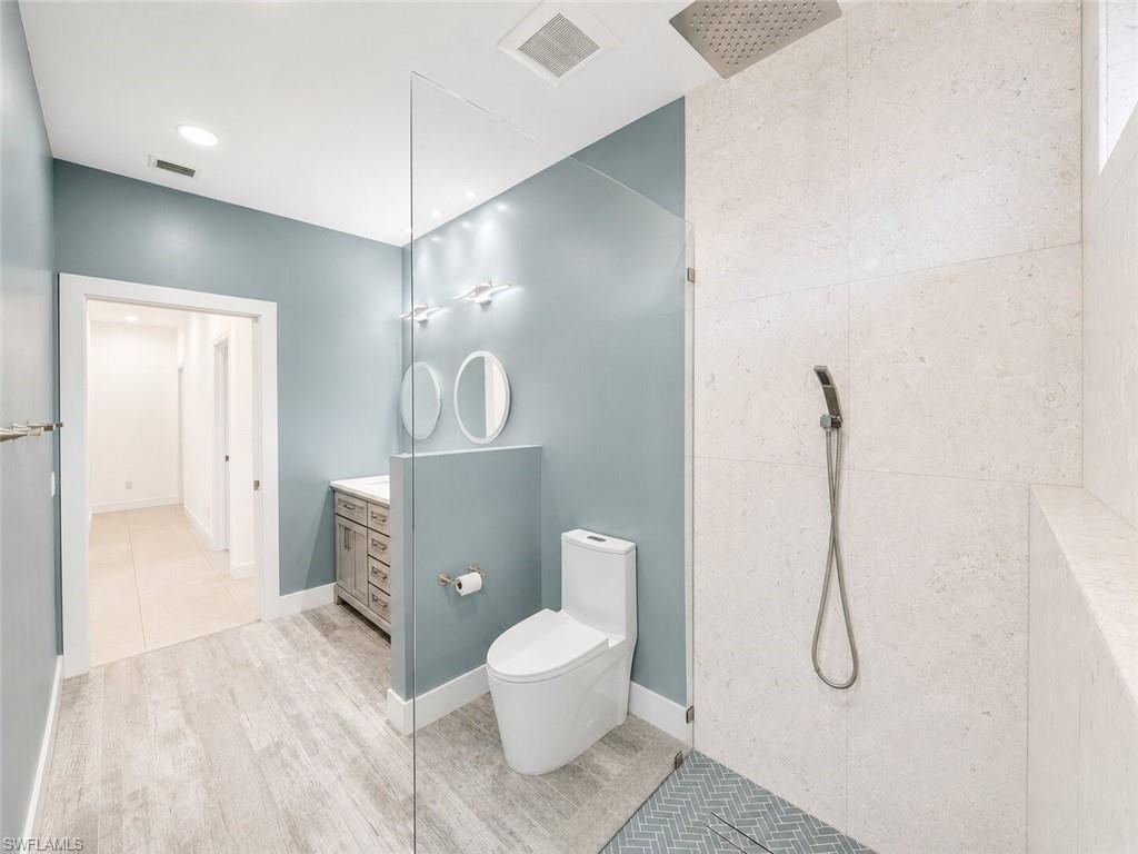 Modern bathroom featuring a spacious walk-in shower with a rain shower head and handheld fixture