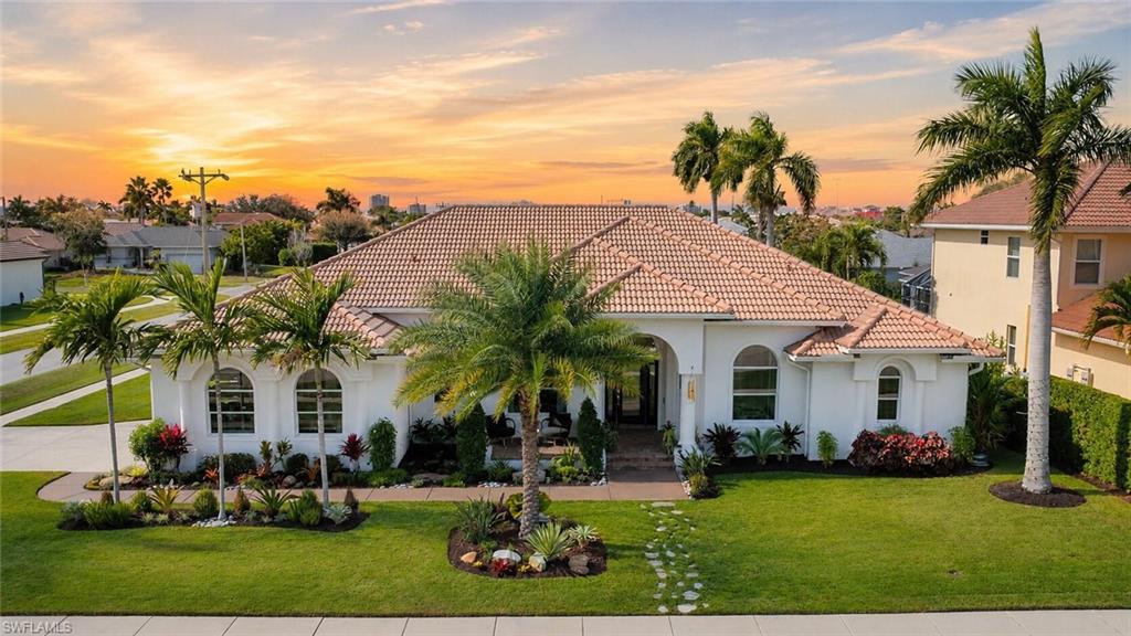 Mediterranean-style residence featuring a tile roof and stucco exterior