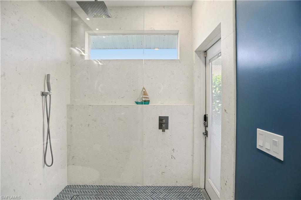 Full bathroom with a tile shower and healthy amount of natural light