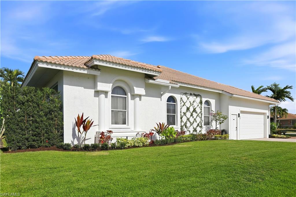 View of front of property with a front lawn, a tiled roof, and stucco siding