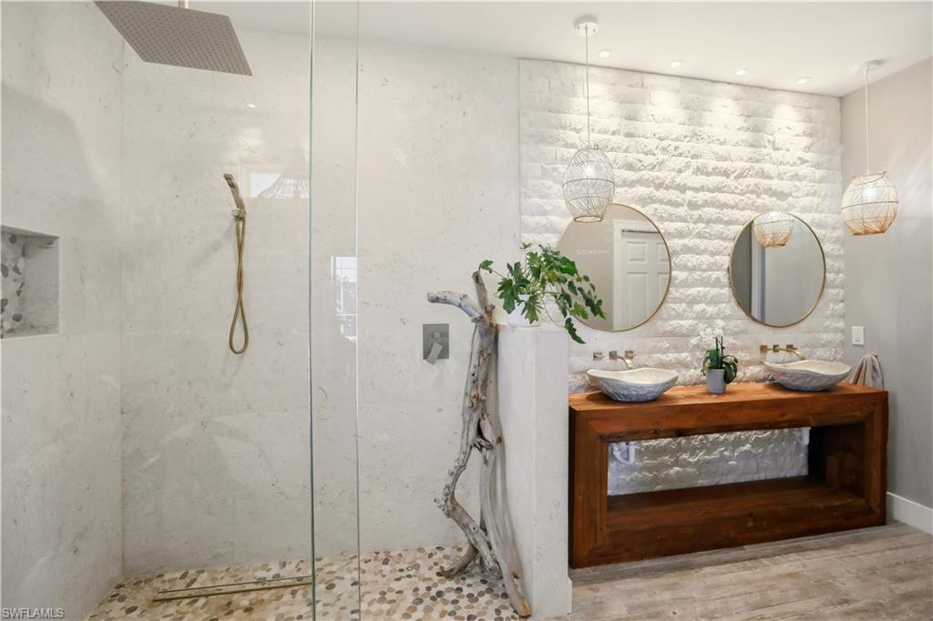 Bathroom with a marble finish shower and double vanity