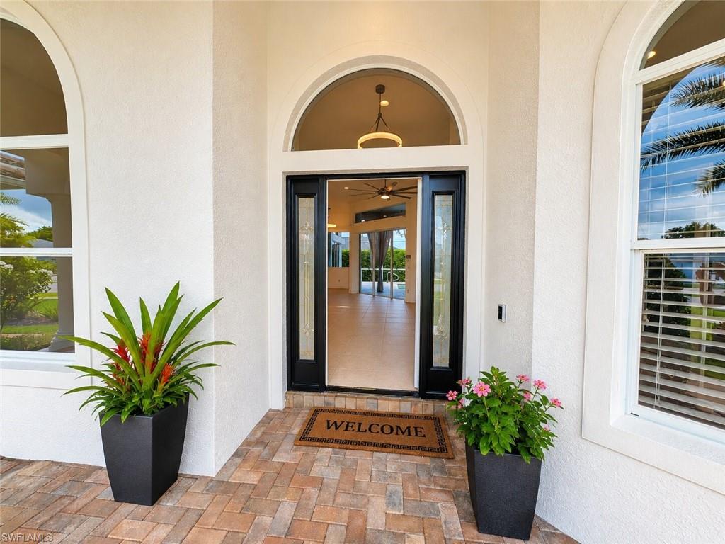 Exterior entry featuring a dark-paneled door with decorative glass inserts and an arched transom window