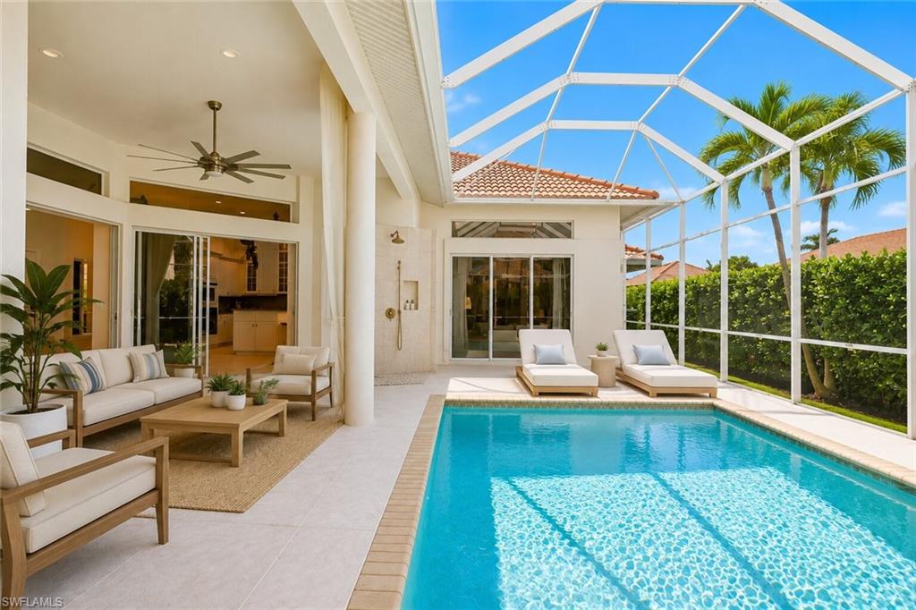 Screened-in pool deck featuring a swimming pool, covered patio with ceiling fan, and outdoor shower