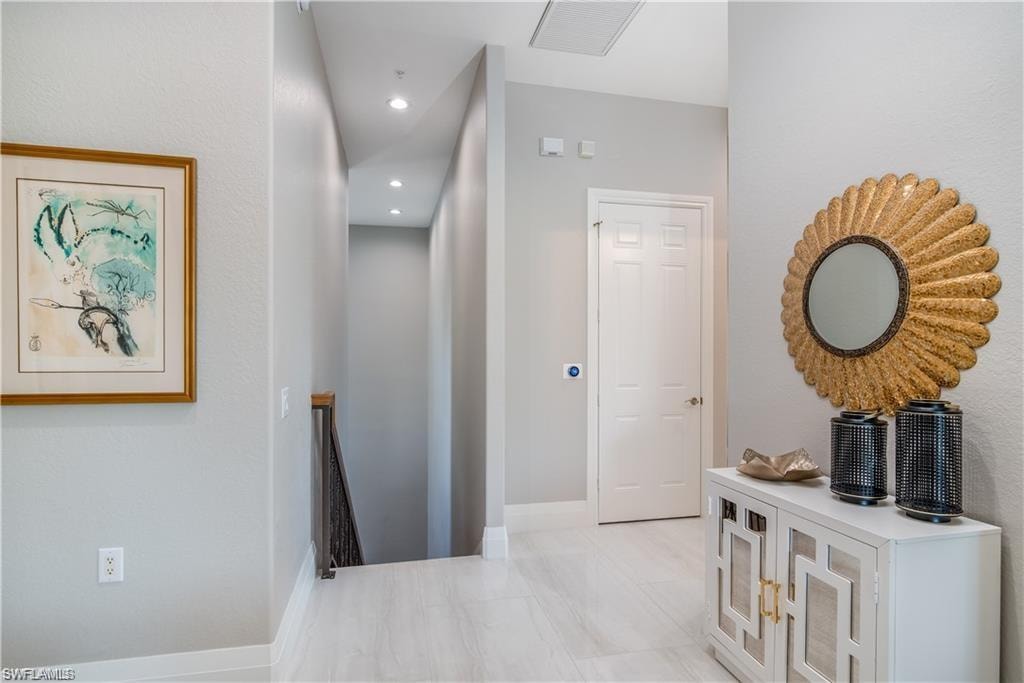 Corridor with an upstairs landing and recessed lighting
