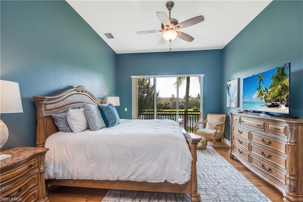 Bedroom with access to outside, wood finished floors, and a ceiling fan