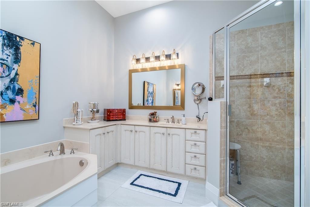 Bathroom with vanity, a garden tub, and a stall shower