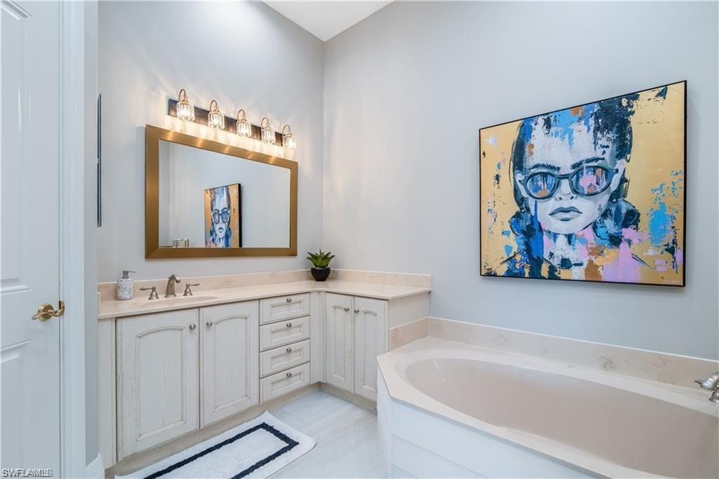 Full bath with vanity and a garden tub