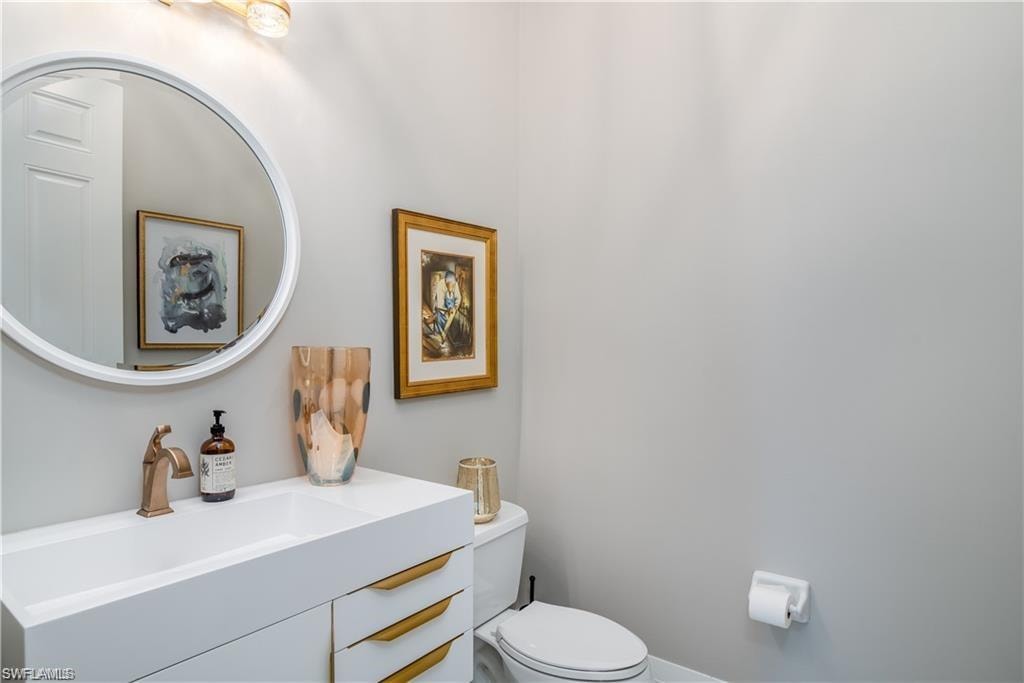 Half bathroom featuring vanity and toilet