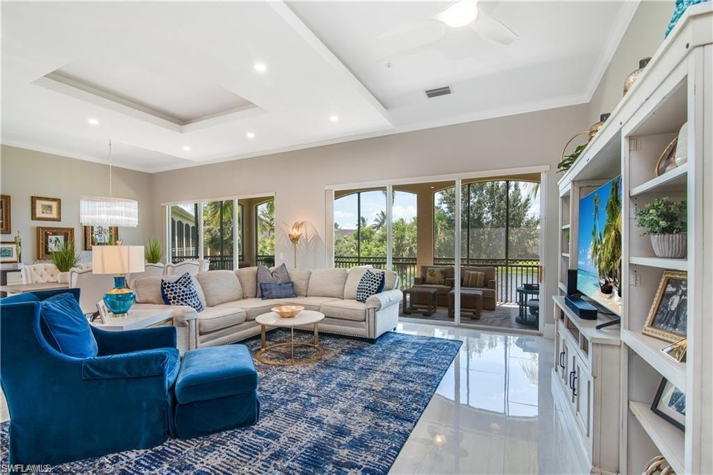 Living room featuring ornamental molding, recessed lighting, and a tray ceiling