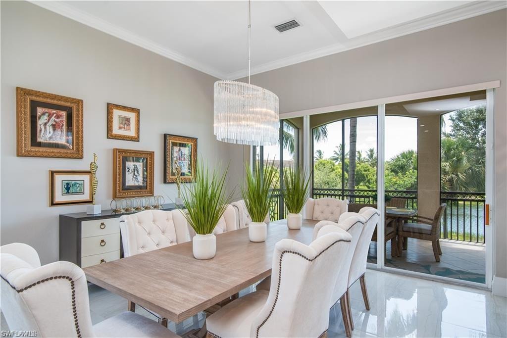 Dining space with crown molding and a chandelier