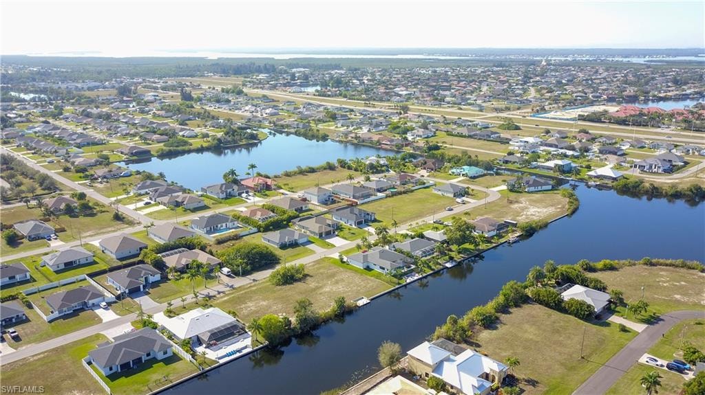 Aerial view of property's location featuring a large body of water and nearby suburban area