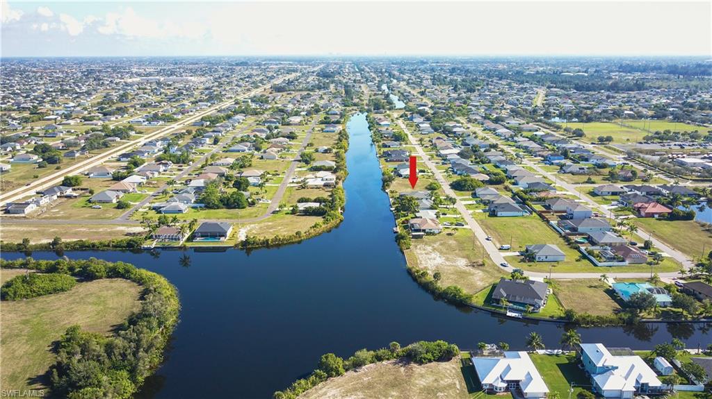 Aerial view of property's location with nearby suburban area and a large body of water