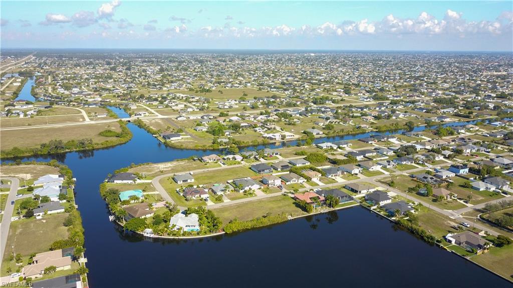 Aerial view of property's location with nearby suburban area and a nearby body of water