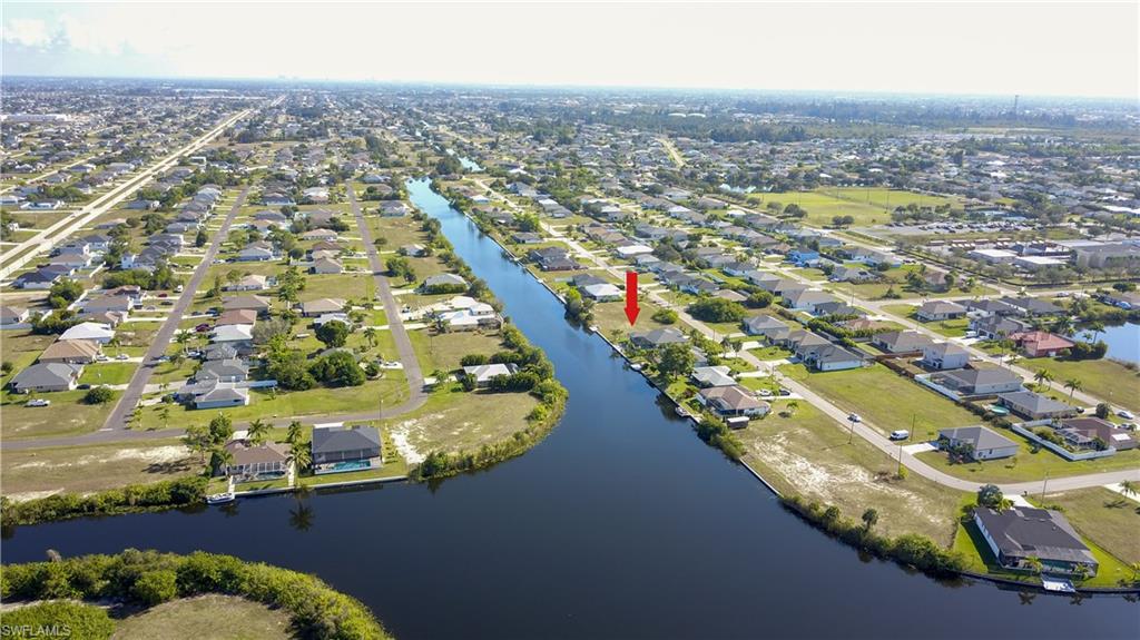 Aerial view of property and surrounding area with nearby suburban area and a large body of water