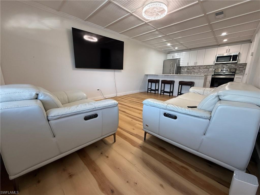 Living room with light wood-style flooring and recessed lighting