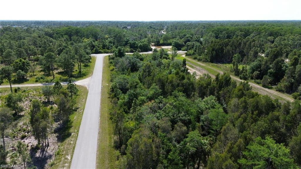 Aerial view of property and surrounding area featuring a forest