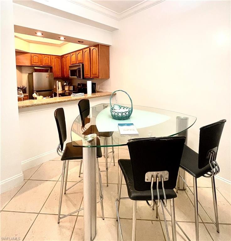 Dining room with  light tile patterned floors, and recessed lighting