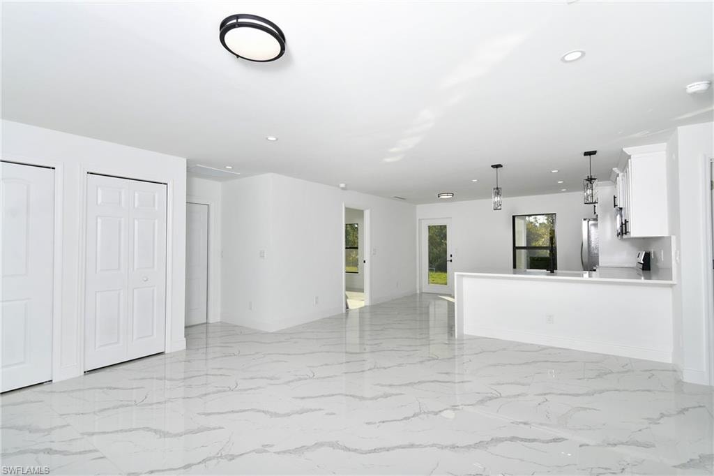 Unfurnished living room featuring recessed lighting and light marble finish floors