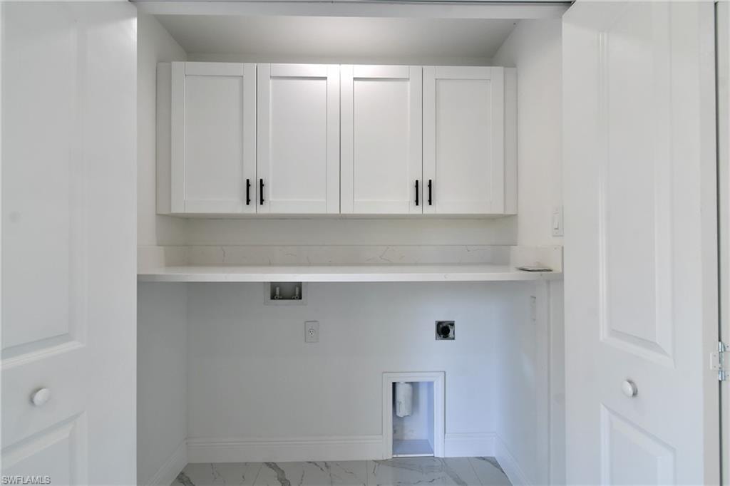 Washroom featuring light marble finish floors, cabinet space, hookup for an electric dryer, and washer hookup
