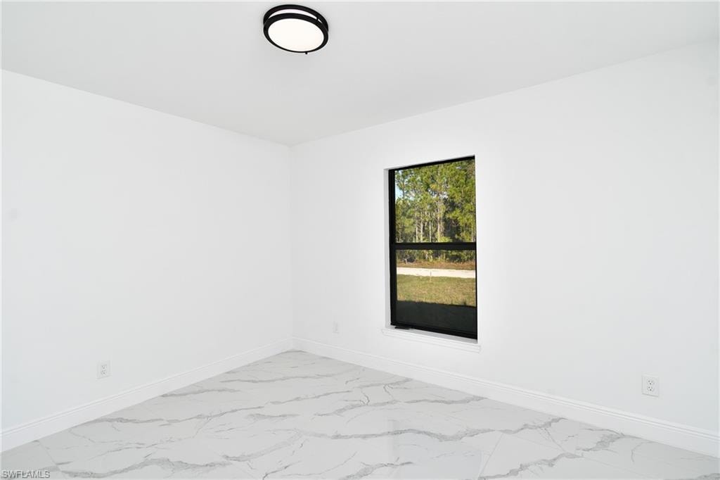 Unfurnished room featuring light marble finish floors