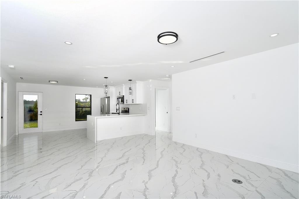 Unfurnished living room featuring recessed lighting and light marble finish floors
