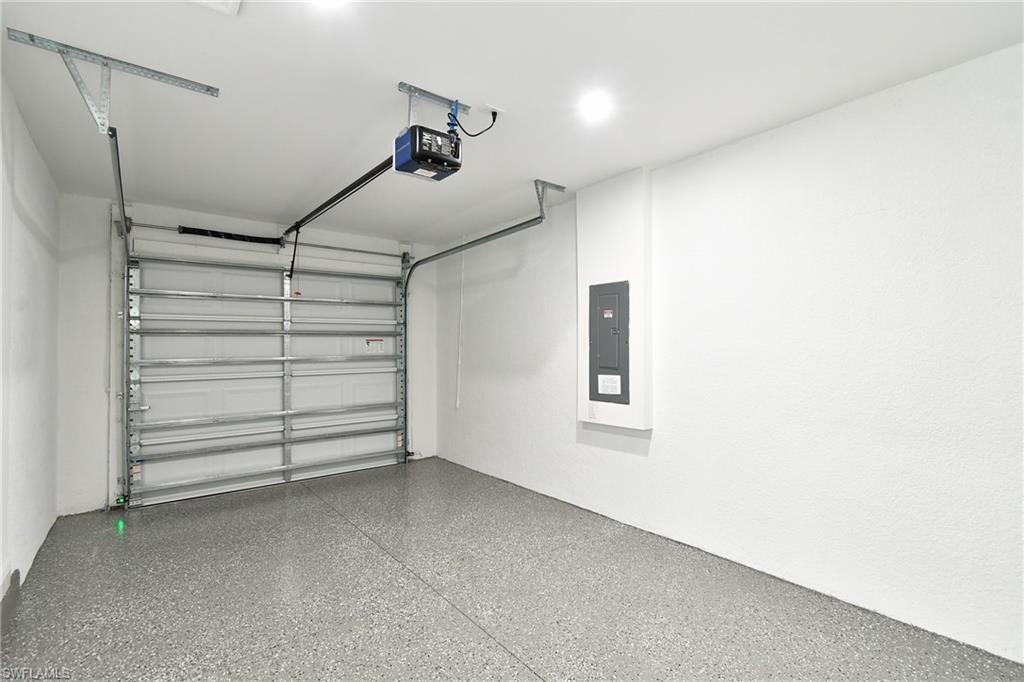 Garage featuring electric panel and a garage door opener