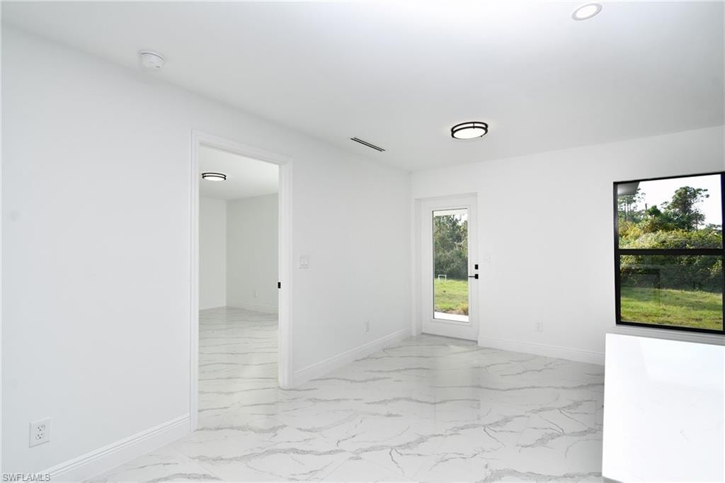 Spare room with baseboards and light marble finish flooring