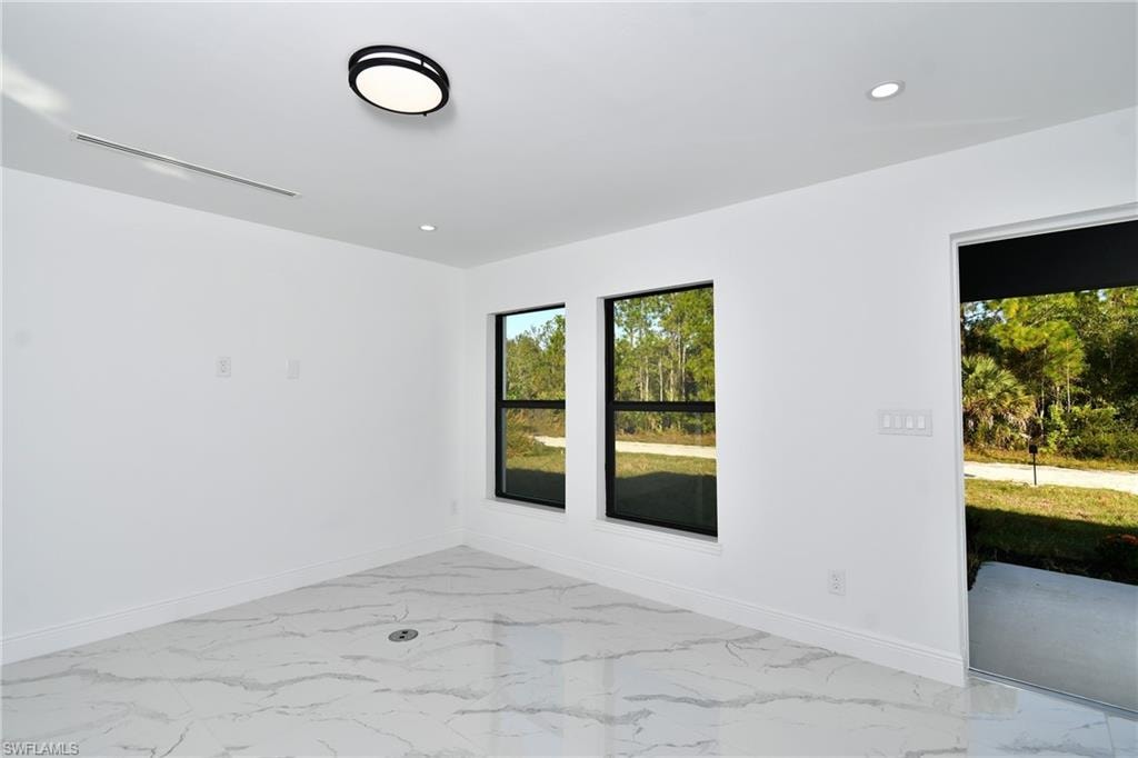 Spare room featuring light marble finish floors and recessed lighting