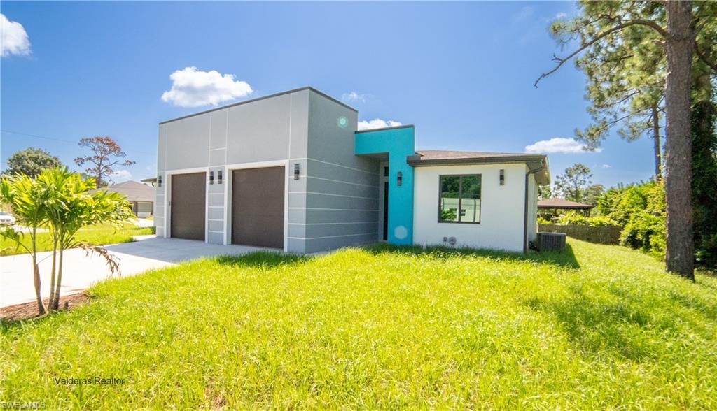 Modern home featuring stucco siding, a front lawn, concrete driveway, and a garage
