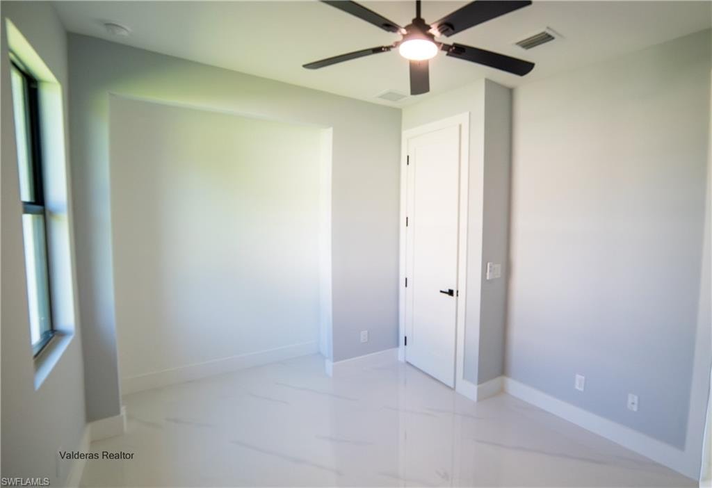 Unfurnished bedroom with a ceiling fan and baseboards