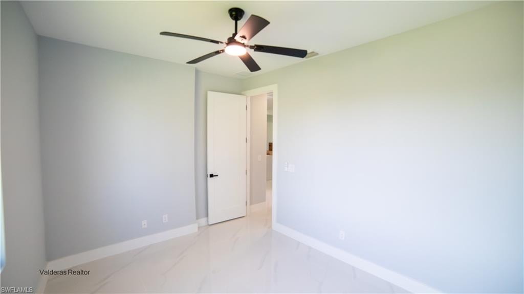 Spare room with light marble finish flooring and ceiling fan