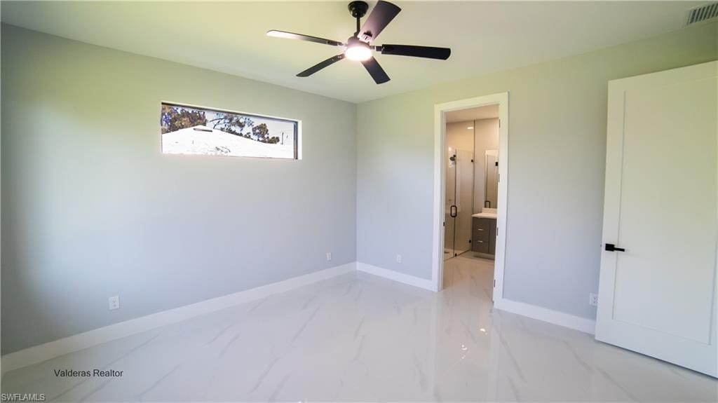 Unfurnished bedroom with a ceiling fan and ensuite bathroom