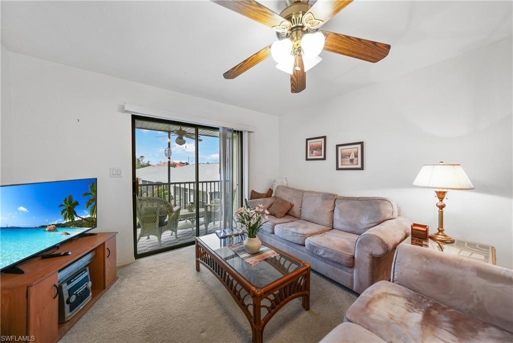 Living area with light colored carpet and a ceiling fan