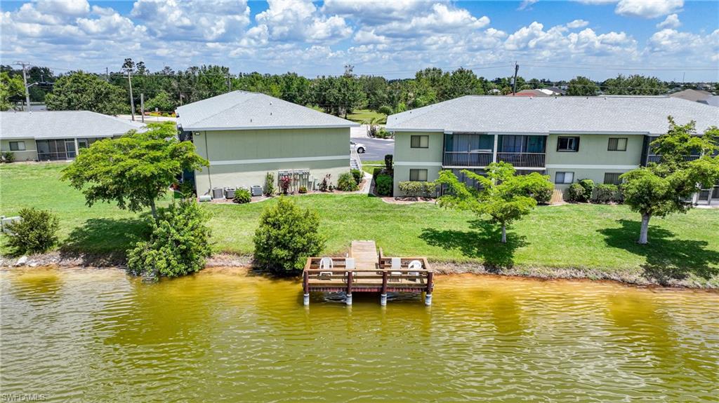 Dock area featuring a water view, a yard, and view of wooded area
