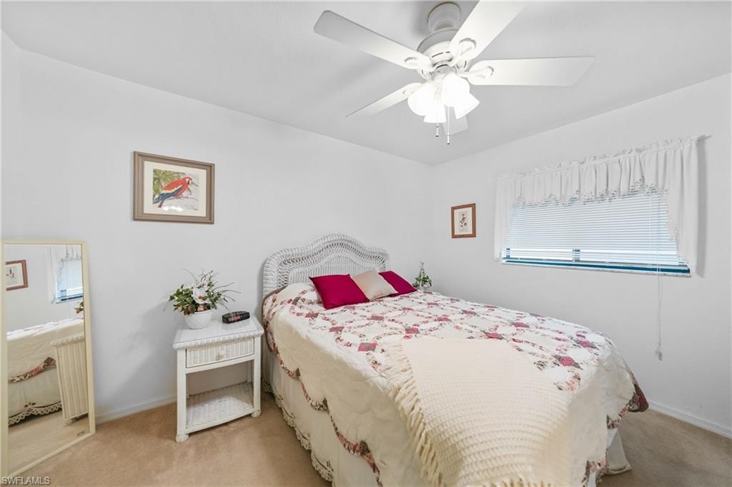 Carpeted bedroom with radiator and a ceiling fan