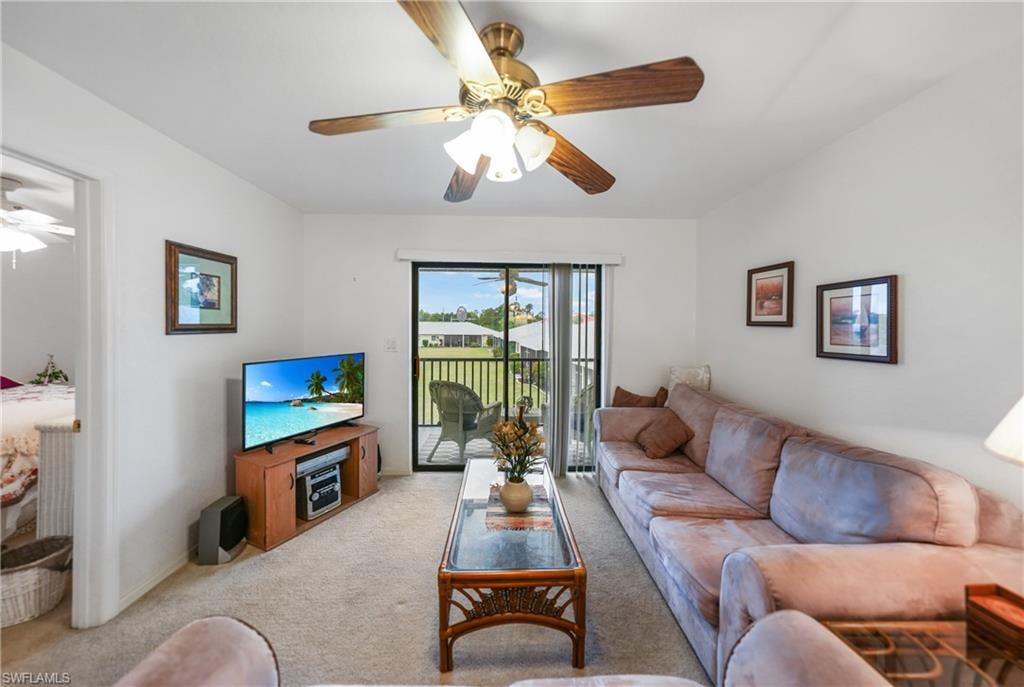 Living room with a ceiling fan and light colored carpet