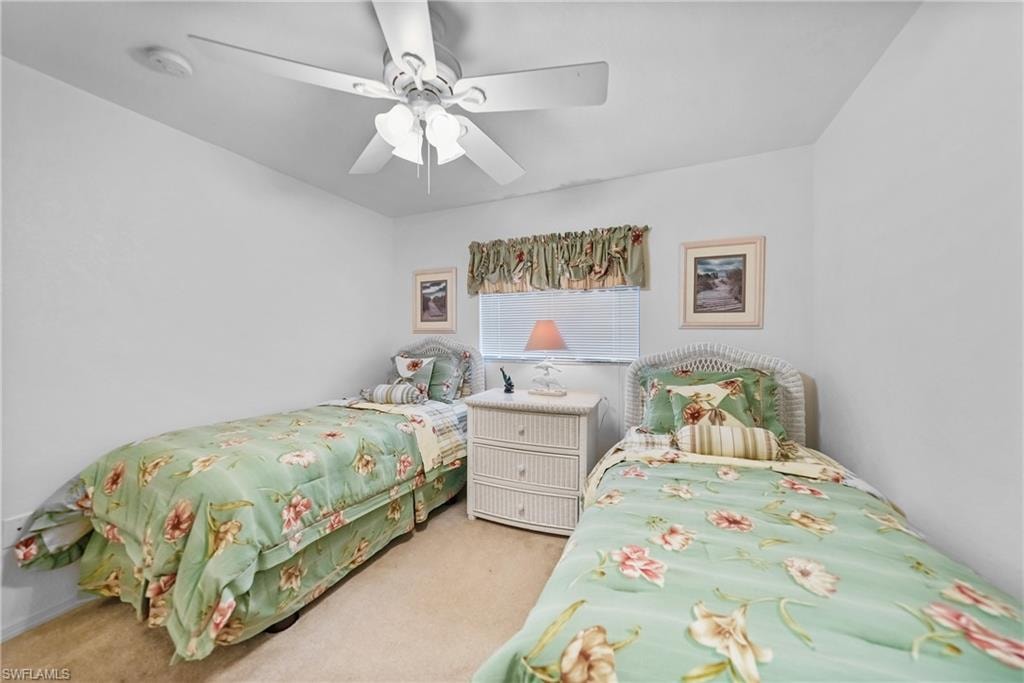 Carpeted bedroom featuring ceiling fan