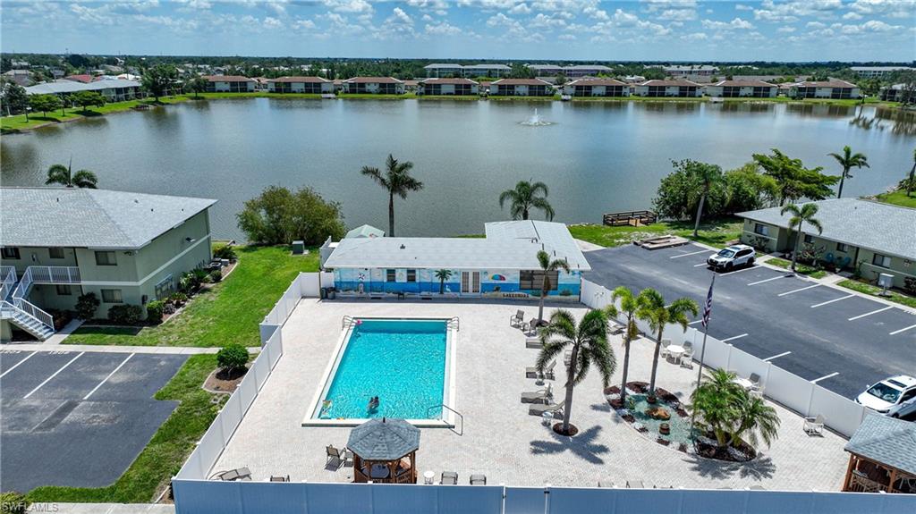 Drone / aerial view of a pool area and a nearby body of water
