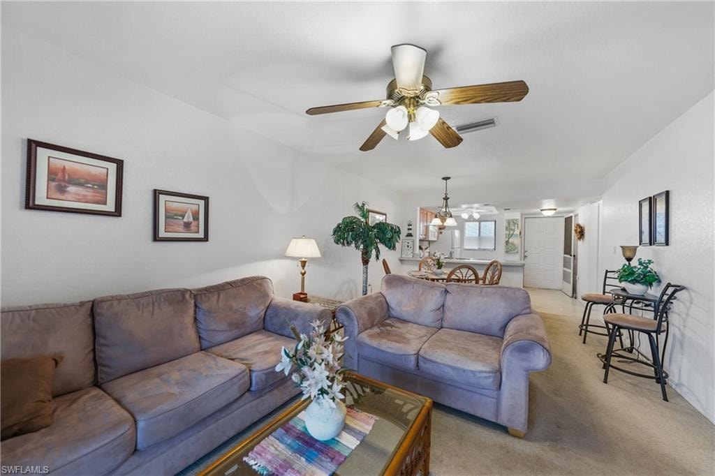 Living area with carpet flooring and ceiling fan
