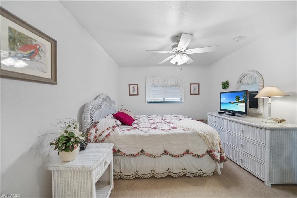 Bedroom with light colored carpet and ceiling fan