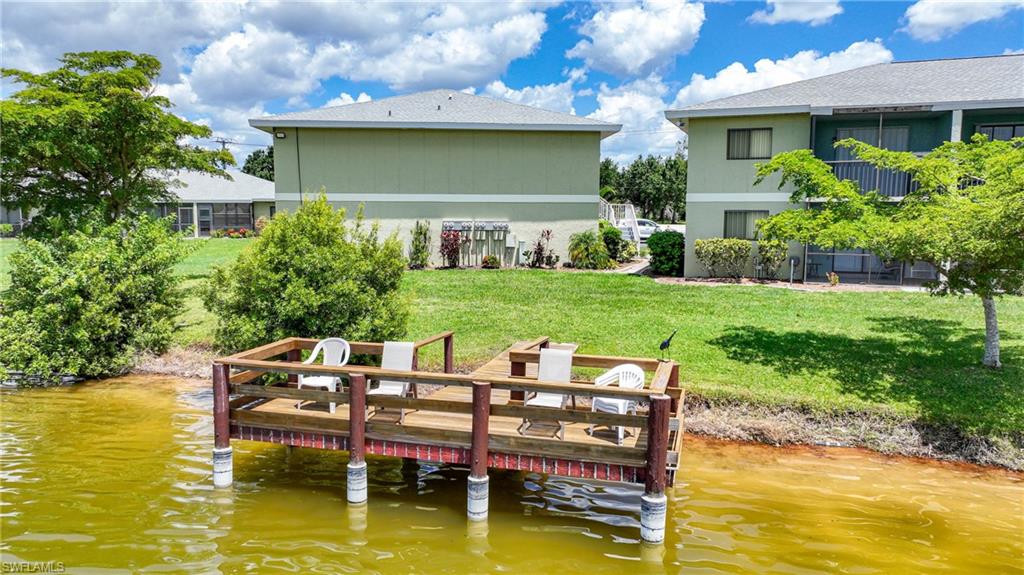 Dock area featuring a water view and a lawn