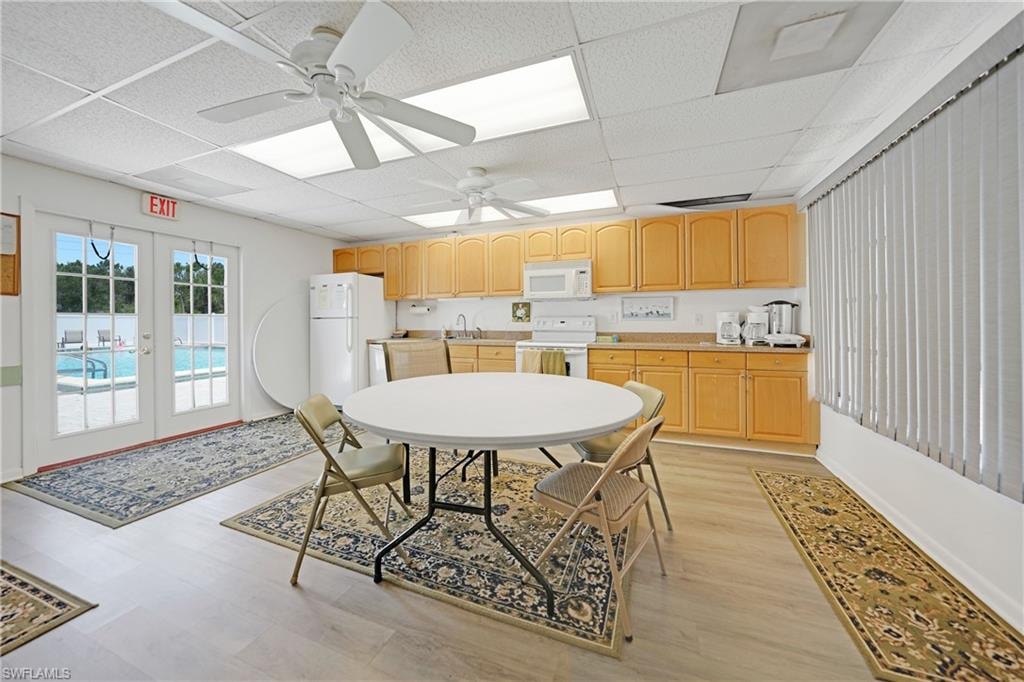 Kitchen with french doors, white appliances, a drop ceiling, ceiling fan, and light brown cabinets