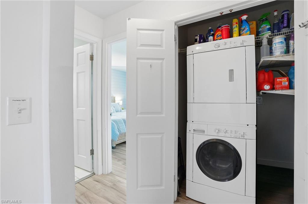 Washroom featuring stacked washer / dryer and light wood finished floors - Virtually Edited Image