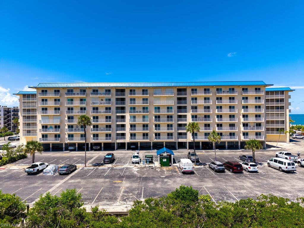View of apartment building / complex with uncovered parking