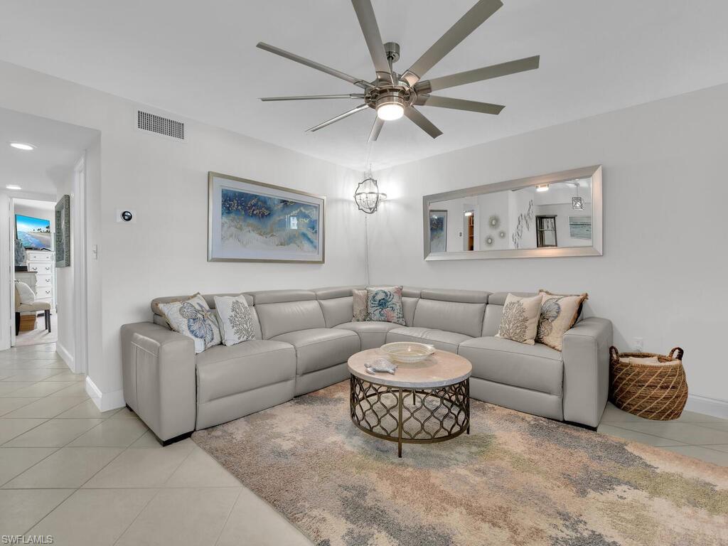 Living area featuring light tile patterned floors and ceiling fan