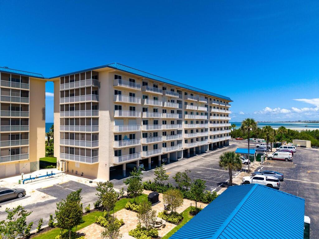 View of apartment building / complex featuring uncovered parking