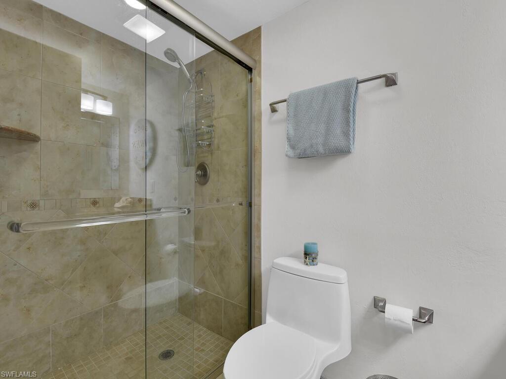 Bathroom with a shower stall and toilet