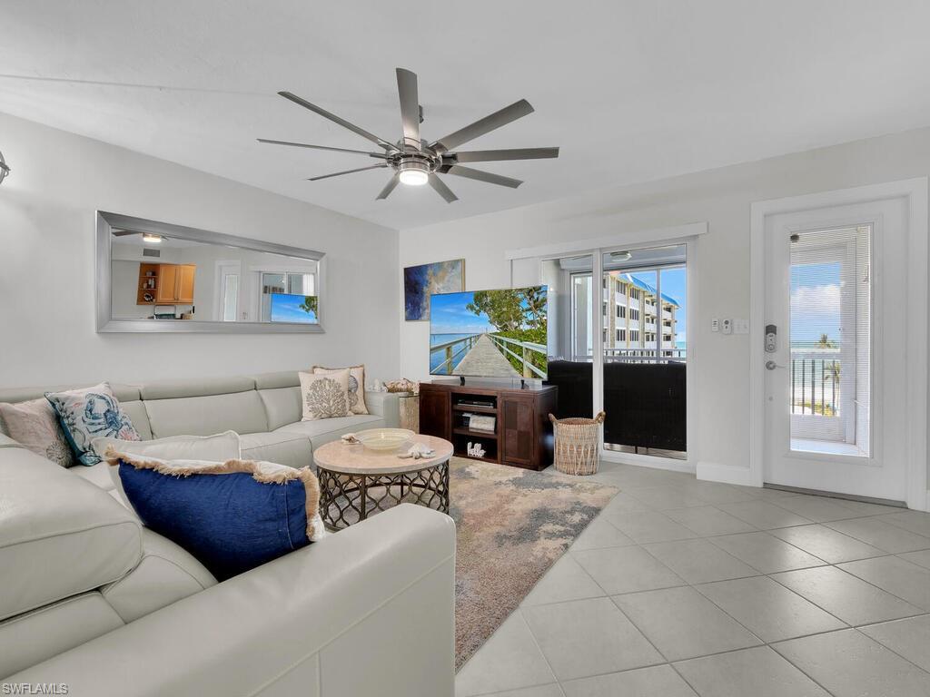 Living area featuring plenty of natural light, tile patterned flooring, and ceiling fan
