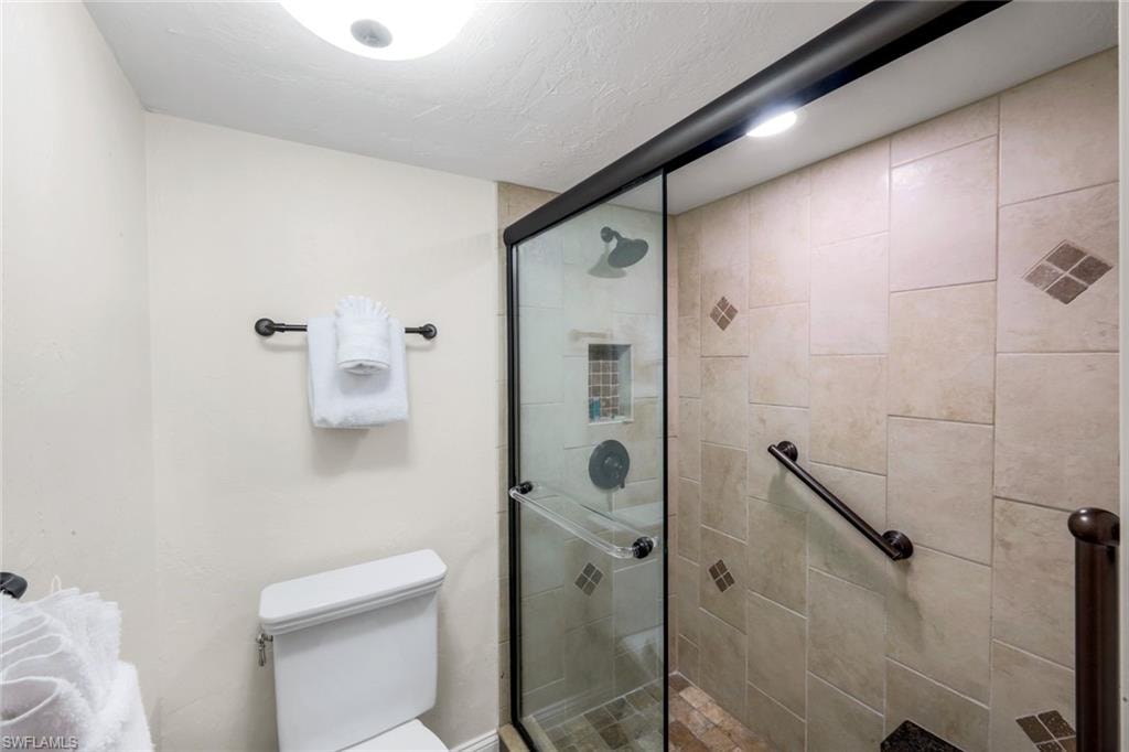 Full bathroom with toilet and a shower stall